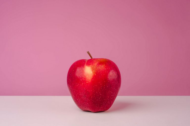 Red delicious apple on pink background